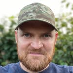 Man with a beard wearing a camouflage cap outdoors